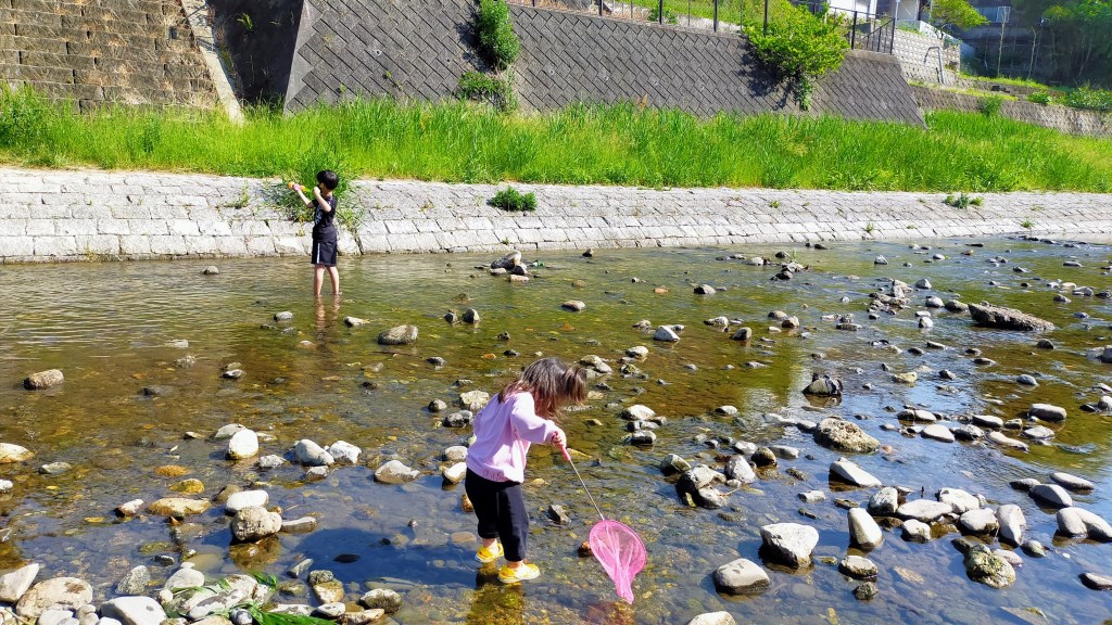 小学生の男の子と1歳の女の子がくろまろの郷近くの石川河川敷で川遊び